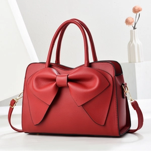Elegante rote Handtasche aus strukturiertem Leder mit großer Schleife und Goldakzenten