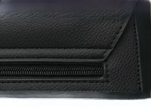 Detail showing precise stitching and smooth edges on black lychee grain leather handbag