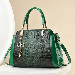Elegant green crocodile pattern handbag with gold hardware and pearl pendant detail