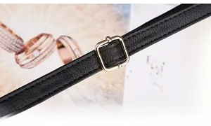 Detail of adjustable golden metal buckle on black lychee grain leather shoulder strap