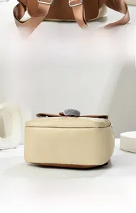 Vue détaillée du sac à dos bicolore marron et beige montrant les bretelles et le fond