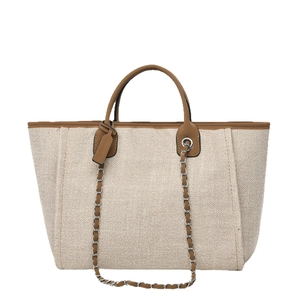 Minimalist beige canvas tote bag with brown leather trim and silver chain strap details
