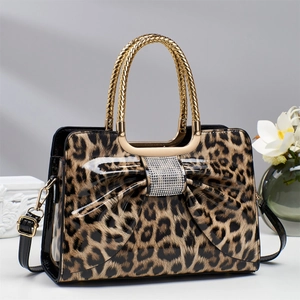 Leopard print handbag with bow and rhinestone detail, featuring gold woven handle