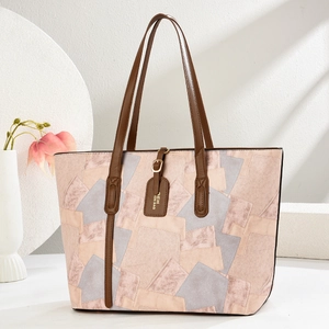 Color-block large tote bag in pink and beige with brown leather handles and a luggage tag