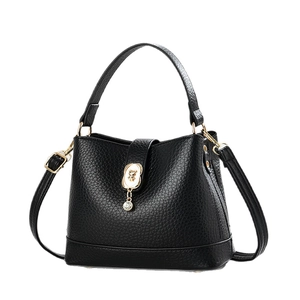 Elegant black lychee grain bucket bag with golden hardware and cute bear pendant charm