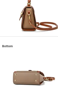 Detail view of the brown pebble leather bag featuring gold hardware and bottom protective studs