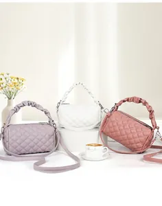 Three elegant quilted mini bags in lavender, white, and pink with ruched handles