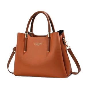 Minimalistische karamellbraune Handtasche aus Leder mit goldenen Details und Trageriemen