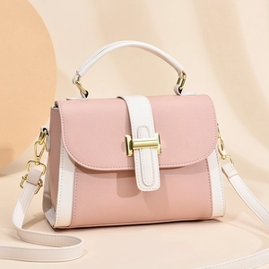 Pink and white lychee leather crossbody handbag with gold hardware on minimalist background