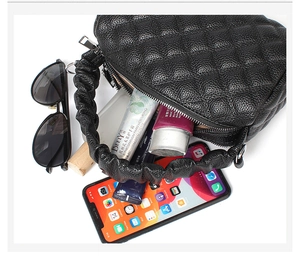 Detailed top view of black quilted mini bag showing interior capacity and lychee leather texture