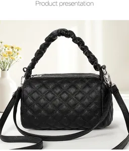 Detail of black quilted leather handbag with ruched handle and silver hardware