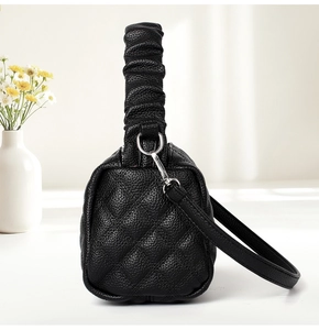 Close-up of black quilted leather crossbody bag with a ruched cloud-style top handle