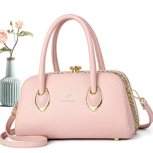Detailed close-up of pink leather handbag with gold chain and TUBOYANG logo
