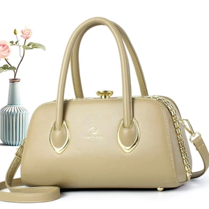 Detail of beige lychee textured handbag with elegant gold hardware and teardrop accents