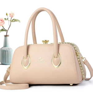 Macro shot of apricot crescent handbag showing lychee pattern leather and gold metal buckle