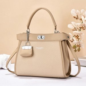 Sac à main beige élégant à texture tissée avec fermoir en métal et mini pendentif