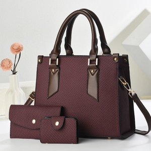 Three-piece set detail showing burgundy woven tote bag with brown leather handles and hardware
