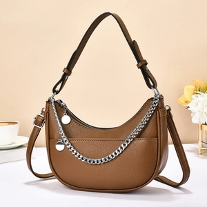 Close-up of brown pebbled leather crescent bag with silver chain and dual straps