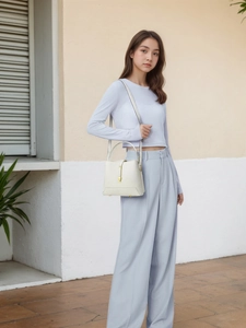 Détail du sac seau en cuir grainé blanc cassé avec fermoir métallique doré élégant
