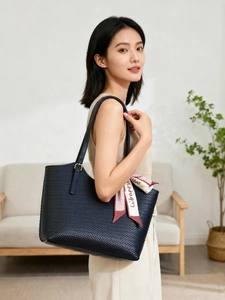 Detailed texture of navy woven tote bag featuring a decorative printed silk scarf on handle