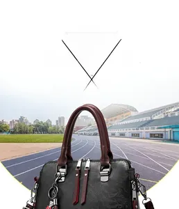 Detail view of retro faux leather handbag with burgundy top handle and silver hardware