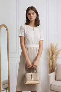 Detail of elegant cream handbag with gold metal hardware and textured surface finish
