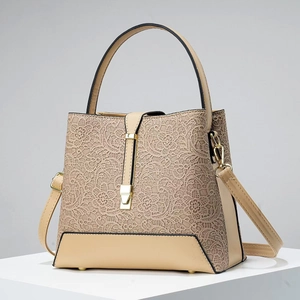 Close-up of beige floral lace pattern and gold-tone hardware on PU leather handbag