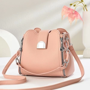 Detail view of pink bucket bag with lychee grain leather and silver hardware accents