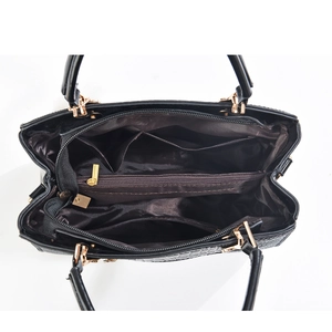 Detail view of large crocodile pattern handbag showing black leather and spacious brown interior