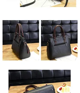 Close-up of litchi pattern leather texture and contrast brown handle on black tote bag