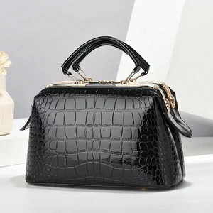 Detailaufnahme der schwarzen Kroko-Handtasche mit elegantem goldenem Metallrahmen