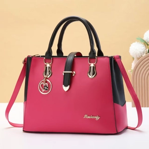 Elegant rose red and black handbag with a golden logo and stylish floral pendant