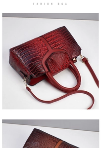 Detailed macro shot of the deep red crocodile pattern texture on a large tote bag
