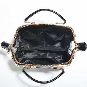 Draufsicht der schwarzen Handtasche mit geräumigen Fächern und goldenen Metallelementen