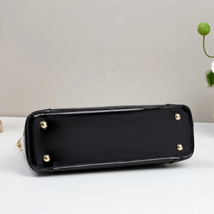 Détails du fond de sac en cuir verni brillant avec quatre pieds de protection dorés