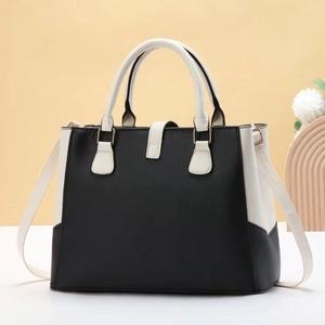 Detail of minimalist black and white tote bag with gold hardware and adjustable strap