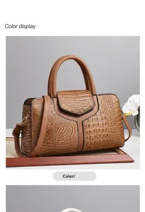 Close-up of khaki crocodile pattern handbag featuring a top handle and adjustable strap