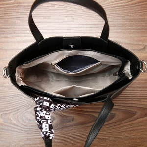 Vue intérieure du sac cabas noir montrant trois compartiments et poches zippées