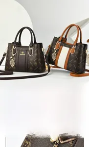 Detail of lychee pattern leather handbag with gold leaf pendant and pearl charm decoration