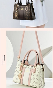 Detail of luxury textured leather tote bag with gold leaf pendant and logo charm