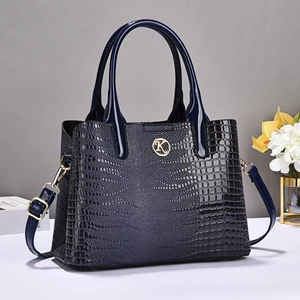 Détail du sac à main bleu marine en cuir verni croco avec logo doré et bandoulière