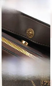 Detail of lychee textured leather tote with gold hardware and brand pattern prints