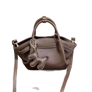 Dark brown pebble leather dumpling handbag with puppy charm and adjustable strap