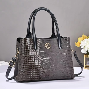 Vue détaillée d'un sac à main gris foncé à motif crocodile avec logo K doré et fleurs