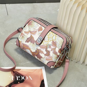 Sac bandoulière brodé de fleurs avec bordure en cuir rose et trois compartiments zippés