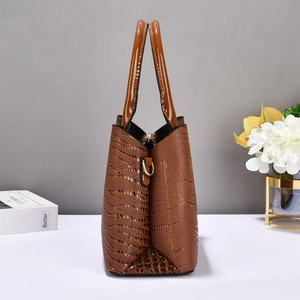 Détail du sac à main marron motif crocodile avec poignées vernies et anneau doré