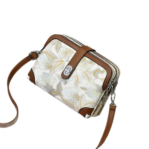 Petit sac carré à motif floral avec garniture en cuir marron et fermoir rotatif argenté