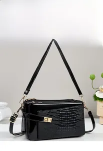 Detail of black faux crocodile skin texture and glossy finish on a stylish handbag