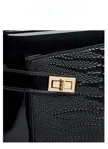 Detailed macro view of black crocodile texture and golden metal lock on handbag