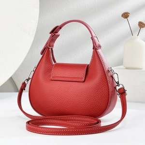 Red crescent moon leather crossbody bag with white stitching and silver hardware